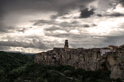 Buildings against cloudy sky at pitigliano