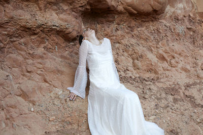 Young woman with a wedding dress in the nature
