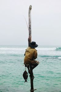 Rear view of man holding umbrella on beach