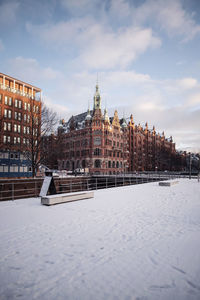 Snow covered buildings against sky
