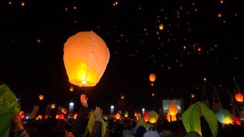 Illuminated lanterns against sky at night