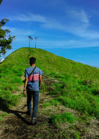 Rear view of man on land against sky