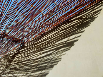 Close-up of metallic structure on beach against sky on sunny day