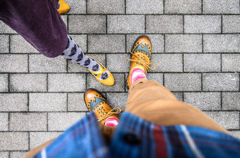 Low section of friends standing on footpath