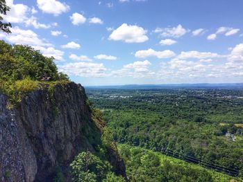 Scenic view of sea and green landscape against sky