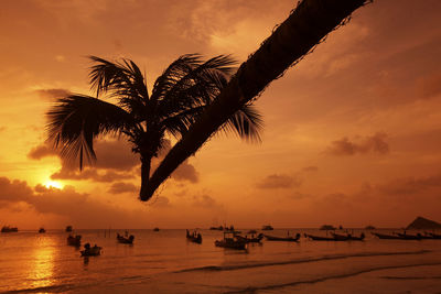 Silhouette people on beach against sky during sunset