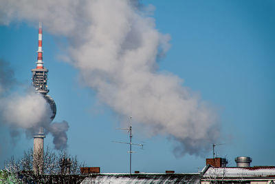 Fernsehturm covered with smoke by industry against clear blue sky