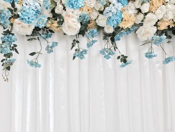 Close-up of white flowers hanging on curtain