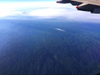Aerial view of airplane wing over sea