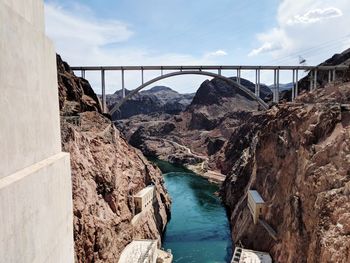 Arch bridge over river against cloudy sky