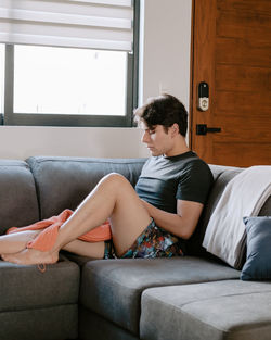 Young woman sitting on sofa at home