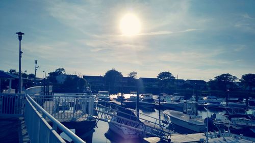 Boats moored at harbor against sky