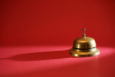 High angle view of bell on table against red background