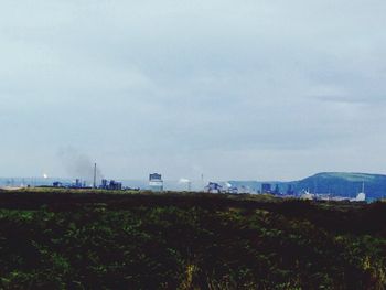 Built structure on landscape against cloudy sky