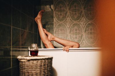 Low section of man with arms raised in bathroom