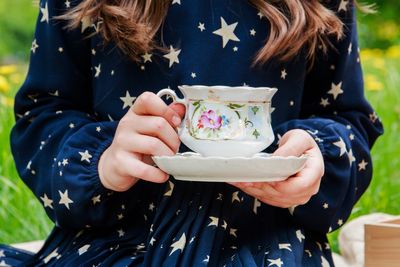 Midsection of girl holding crockery