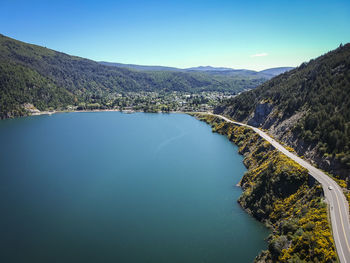 Scenic view of lake and mountains against blue sky