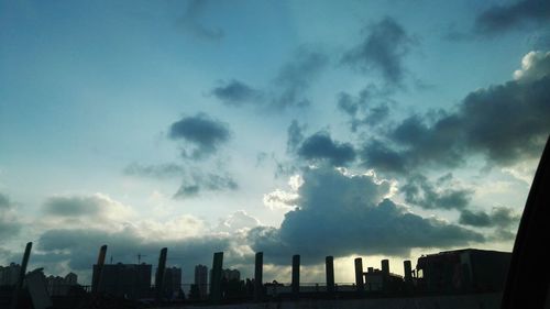 Buildings in city against cloudy sky