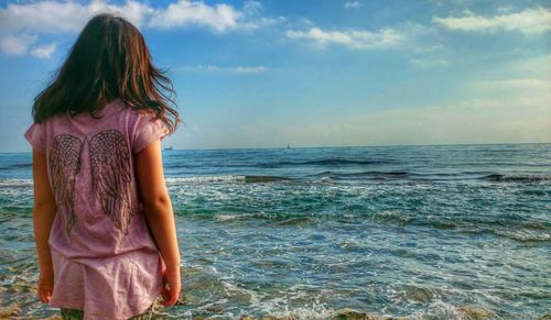 Rear view of woman looking at sea against sky