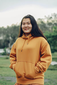 Portrait of young woman standing against lake