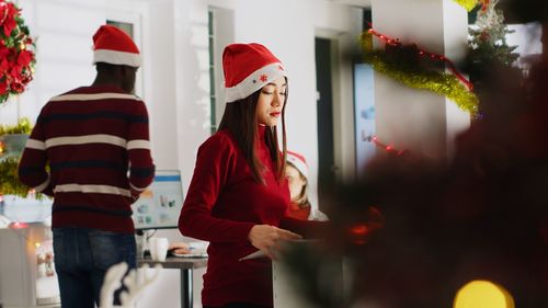 Rear view of woman holding christmas tree