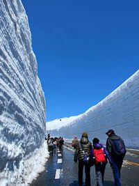 Rear view of people walking on mountain road