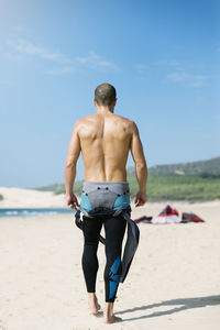 Rear view of shirtless man on beach