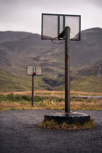 Basketball hoop on field against sky