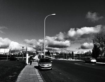 Cars on road against sky in city