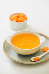 Carrot baby puree in bowl isolated on light background