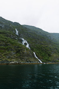 Scenic view of waterfall against sky