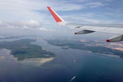 Airplane flying over sea against sky