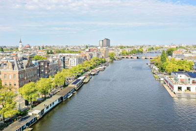 River amidst buildings in city against sky