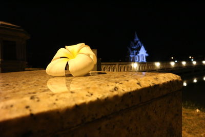 Close-up of food on table against illuminated building at night