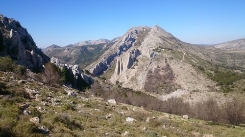 Scenic view of mountains against clear blue sky