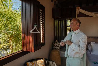 Man standing by window at home