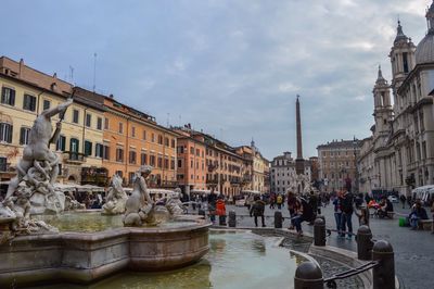 Fountain in city against sky