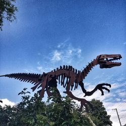 Low angle view of animal sculpture against sky