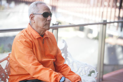 Portrait of young man sitting on railing