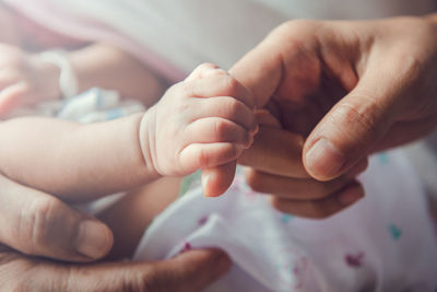 Close-up of baby hand holding fathers finger