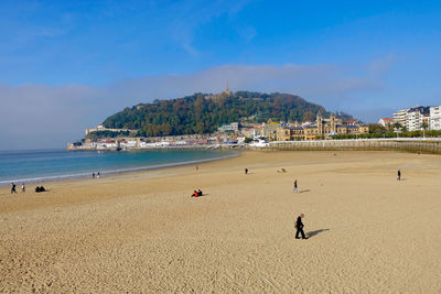 People at beach against sky