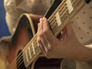 Cropped hand of man playing guitar