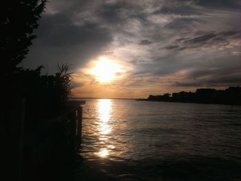 Scenic view of sea against cloudy sky at sunset