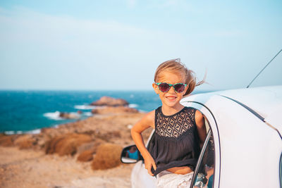 Portrait of man wearing sunglasses at beach against sky