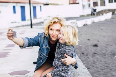 Smiling woman and boy taking selfie on mobile phone