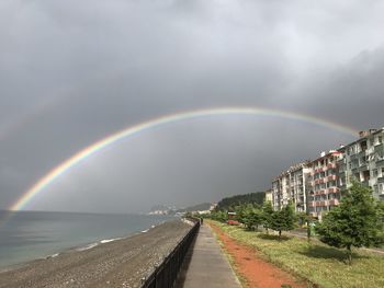 Scenic view of rainbow over city against sky