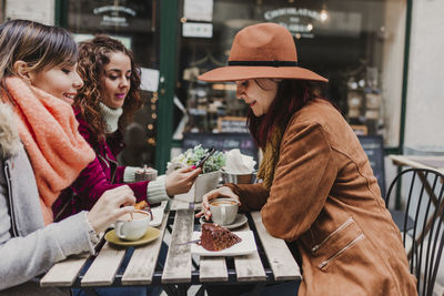 Young woman drinking glasses on table outdoors