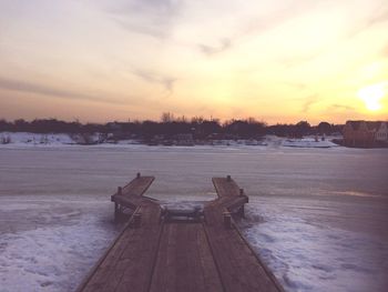 Pier on lake during sunset