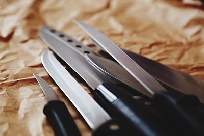 Close-up of knives on paper