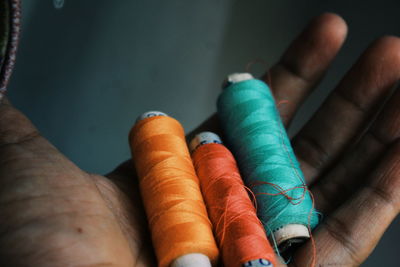 Cropped hand holding thread spools